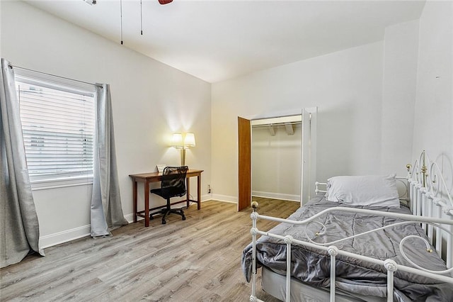 bedroom with ceiling fan, light hardwood / wood-style floors, and a closet