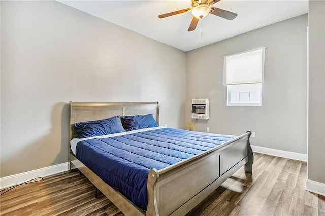 bedroom featuring wood-type flooring, heating unit, and ceiling fan