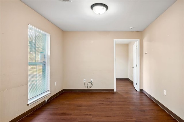 spare room featuring dark hardwood / wood-style floors and a healthy amount of sunlight