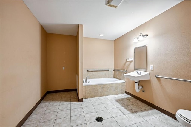 bathroom featuring tiled bath, toilet, and tile patterned floors