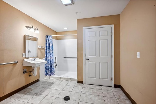 bathroom with sink, curtained shower, and tile patterned flooring