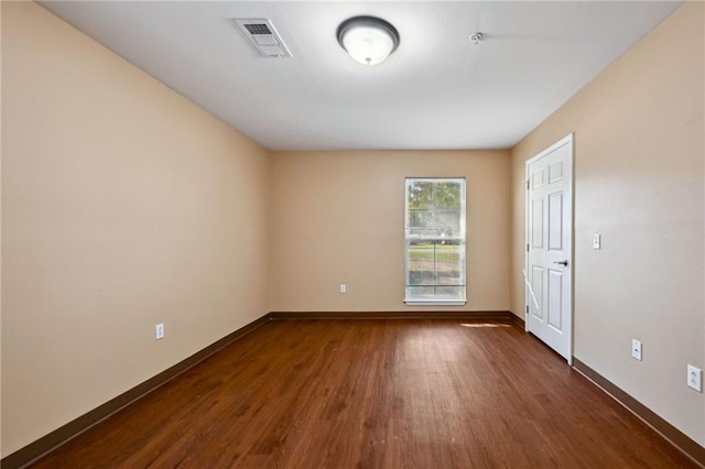 unfurnished room with dark hardwood / wood-style flooring