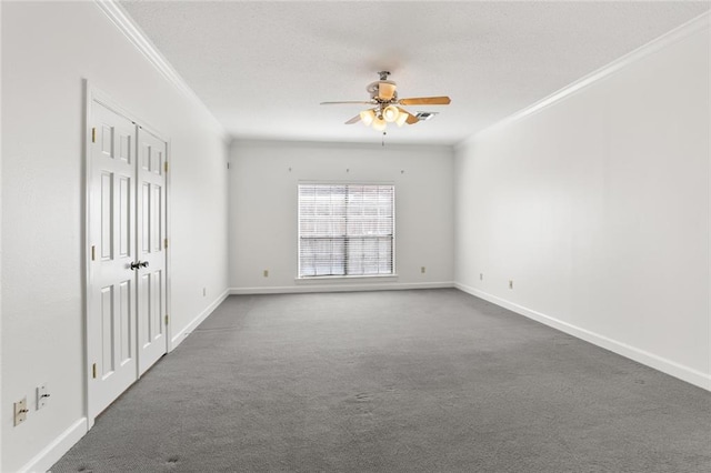 empty room with ornamental molding, carpet, and ceiling fan