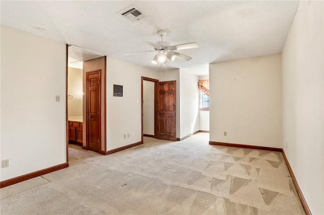 carpeted empty room featuring ceiling fan and a textured ceiling