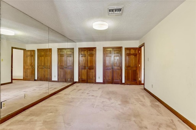 spare room with a textured ceiling and carpet floors