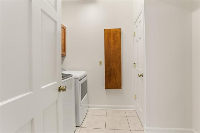 laundry room featuring cabinets, independent washer and dryer, and light tile patterned flooring