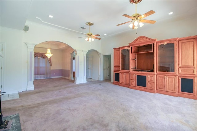 unfurnished living room featuring decorative columns, crown molding, light colored carpet, and ceiling fan