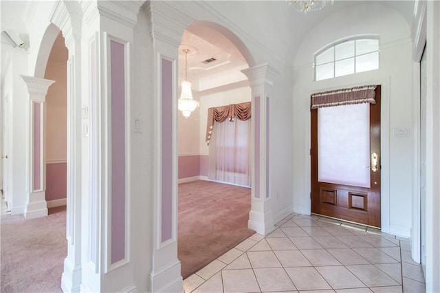 entrance foyer featuring decorative columns and light colored carpet