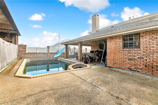 view of swimming pool with a water slide and a patio area