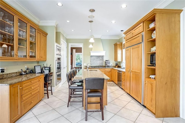 kitchen with a breakfast bar area, built in appliances, light stone countertops, and hanging light fixtures