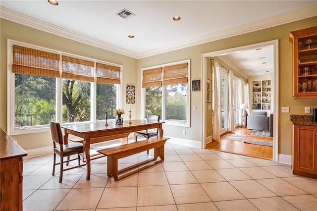 tiled dining room featuring crown molding