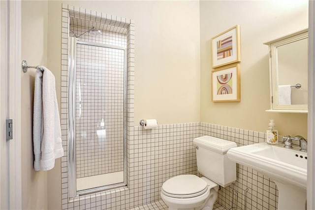 bathroom featuring toilet, an enclosed shower, tile patterned flooring, and tile walls