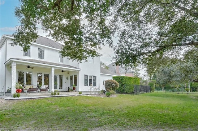 rear view of house with a lawn and ceiling fan