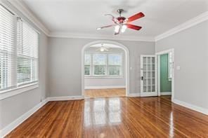 unfurnished room featuring crown molding, hardwood / wood-style floors, and ceiling fan