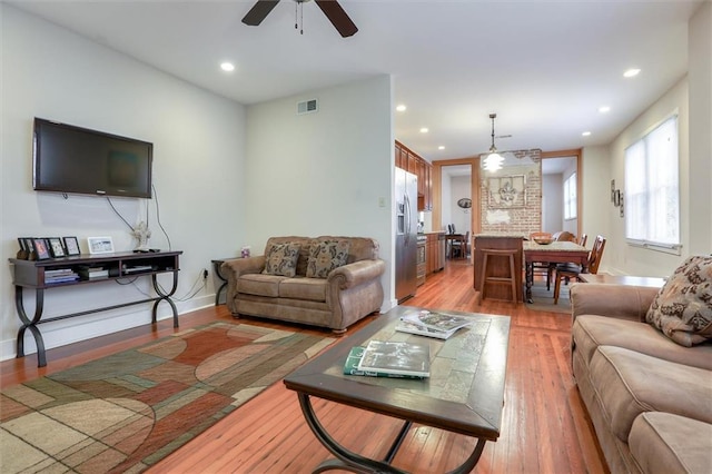 living room with ceiling fan and hardwood / wood-style floors