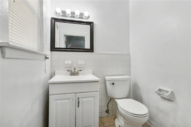 1005 35 Th St, Gretna, LA 70053 - half bathroom featuring tile patterned flooring, vanity, toilet, a wainscoted wall, and tile walls