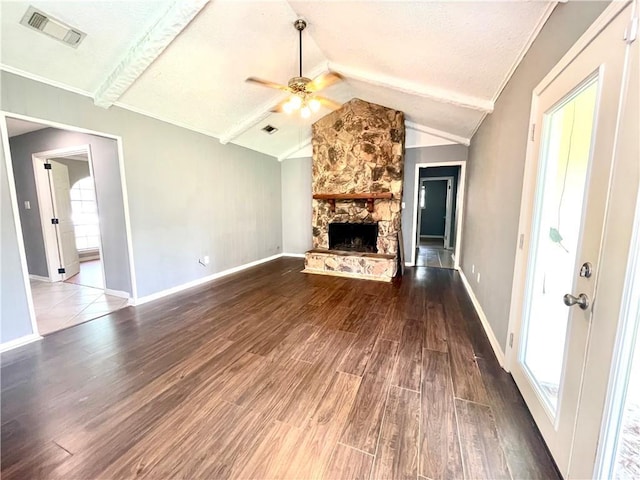 unfurnished living room featuring lofted ceiling with beams, hardwood / wood-style flooring, ceiling fan, a fireplace, and a textured ceiling