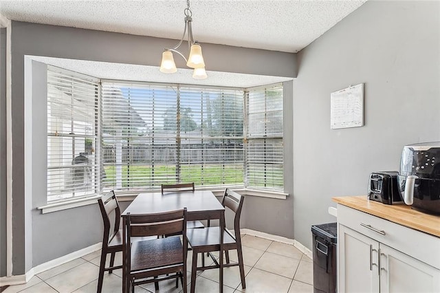 dining area with plenty of natural light, light tile patterned floors, and a textured ceiling