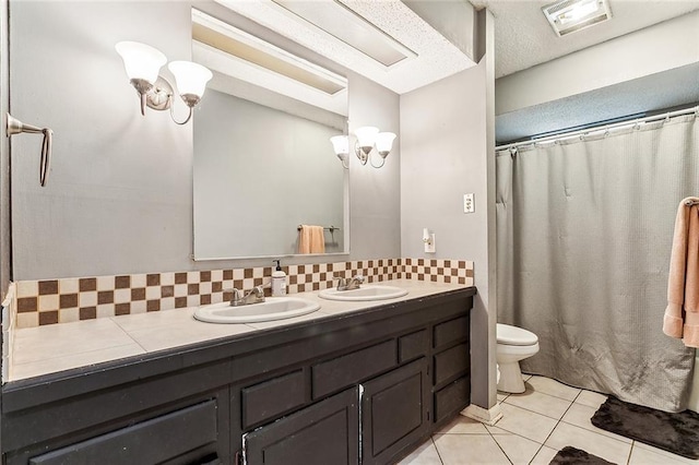 bathroom featuring vanity, tile patterned floors, decorative backsplash, toilet, and a textured ceiling