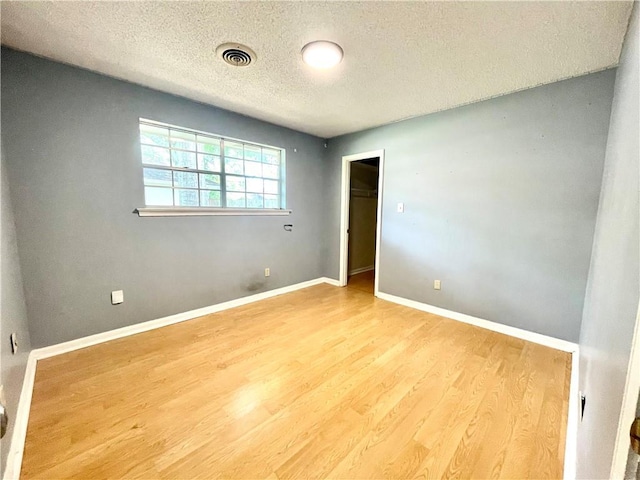 empty room featuring light hardwood / wood-style floors and a textured ceiling