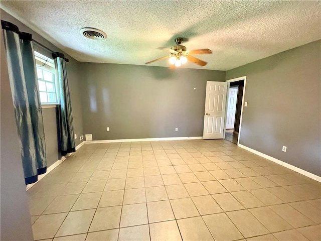 unfurnished room with ceiling fan, light tile patterned flooring, and a textured ceiling