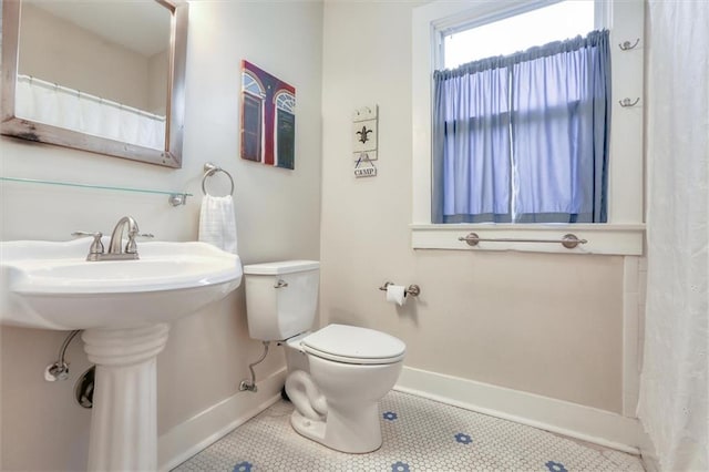 5612 Woodlawn Pl, New Orleans, LA 70124 - full bath featuring baseboards, toilet, tile patterned flooring, and a sink