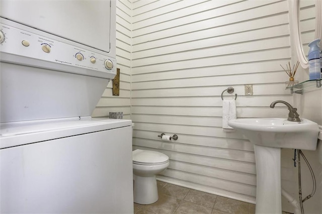 5612 Woodlawn Pl, New Orleans, LA 70124 - half bathroom with stacked washer / drying machine, tile patterned floors, and toilet