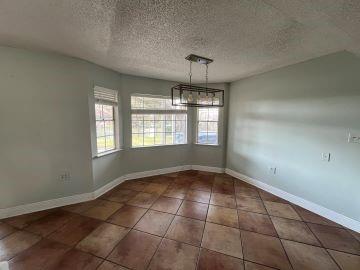 unfurnished dining area with dark tile patterned floors, a chandelier, and a textured ceiling