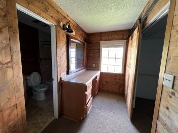 hallway with wood walls, a textured ceiling, and a barn door