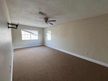 carpeted empty room featuring ceiling fan and a textured ceiling