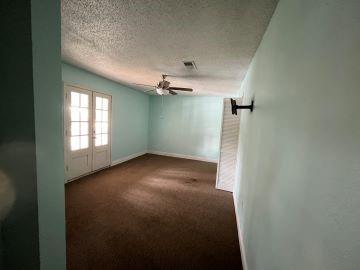 spare room featuring dark carpet, a textured ceiling, and ceiling fan