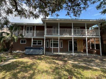 back of house with a patio area, a hot tub, and a balcony