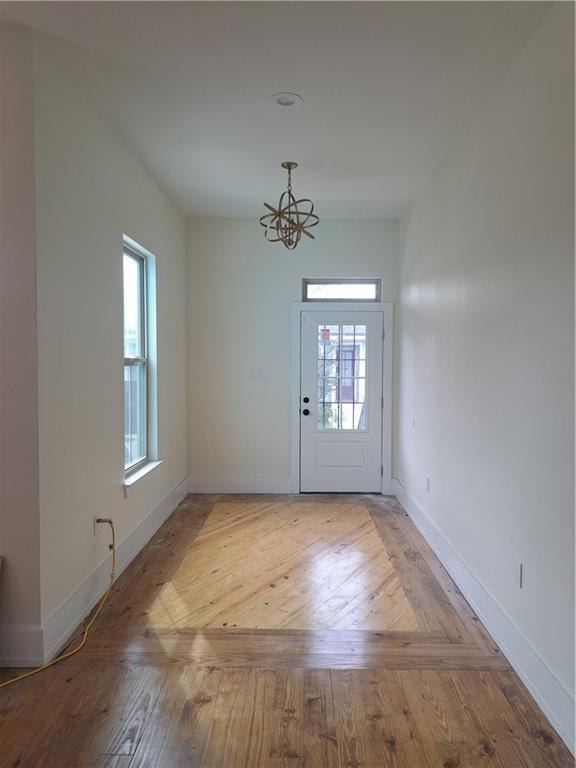 entryway with a notable chandelier and hardwood / wood-style flooring