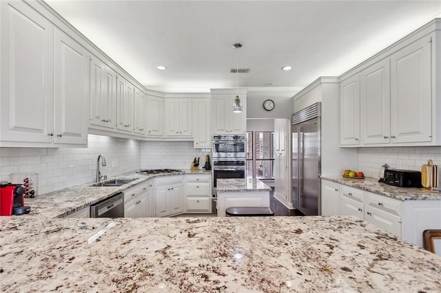 kitchen with white cabinetry, light stone countertops, sink, pendant lighting, and stainless steel appliances