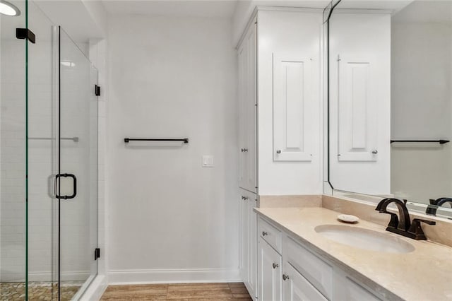 bathroom featuring vanity, a shower with shower door, and hardwood / wood-style floors