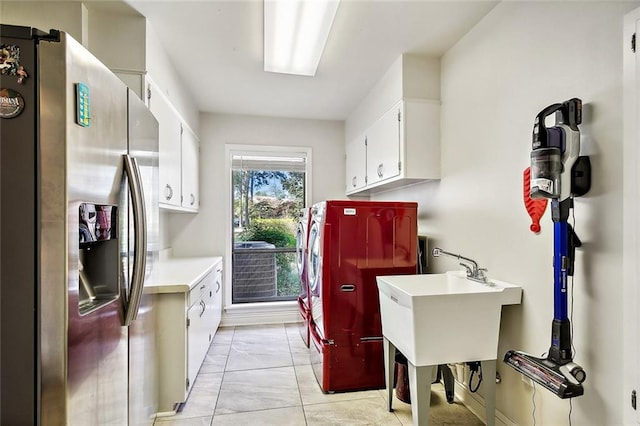 clothes washing area with cabinets and washing machine and clothes dryer