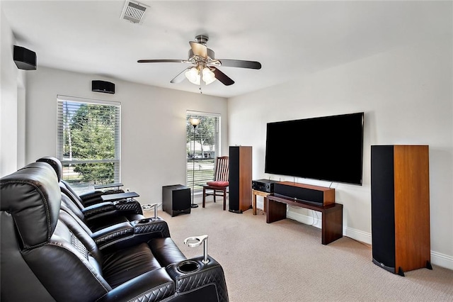 living room featuring ceiling fan, light carpet, and a wealth of natural light