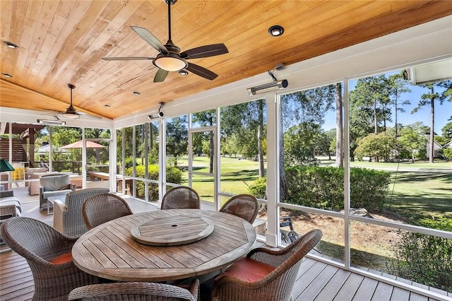 sunroom with ceiling fan, wooden ceiling, and vaulted ceiling