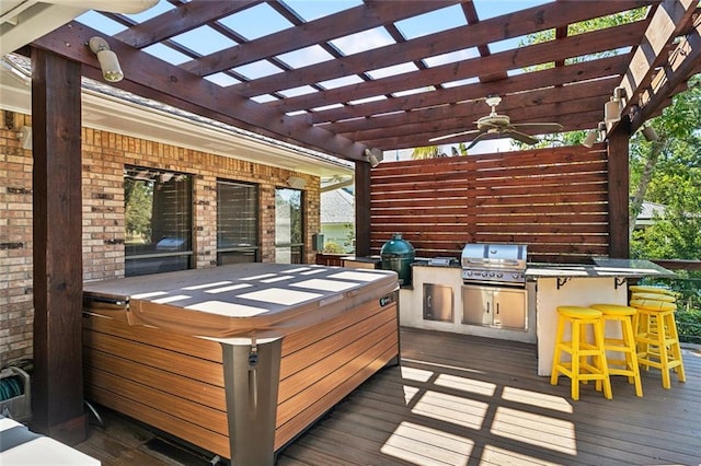 deck with a hot tub, a pergola, ceiling fan, an outdoor bar, and a grill