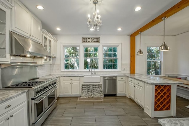 kitchen featuring a wealth of natural light, white cabinetry, kitchen peninsula, and appliances with stainless steel finishes