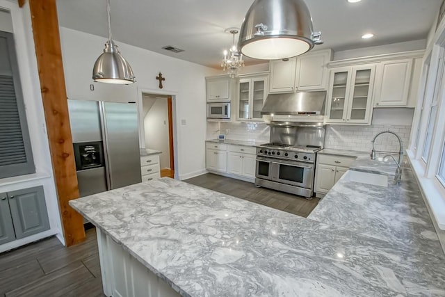 kitchen with white cabinets, tasteful backsplash, decorative light fixtures, light stone counters, and stainless steel appliances