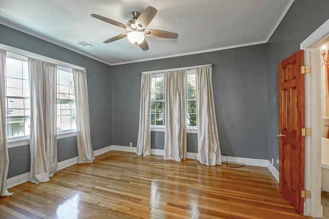 spare room featuring light wood-type flooring, ceiling fan, and ornamental molding