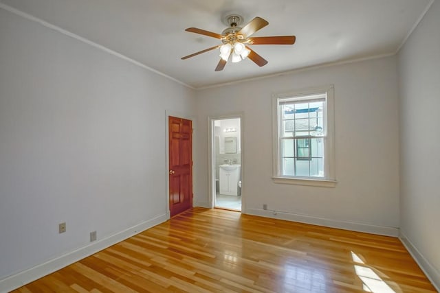 spare room with ceiling fan, ornamental molding, and light wood-type flooring