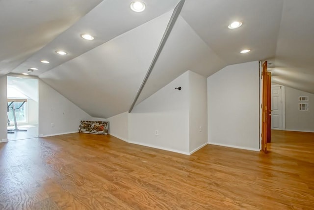 bonus room with light hardwood / wood-style flooring and vaulted ceiling