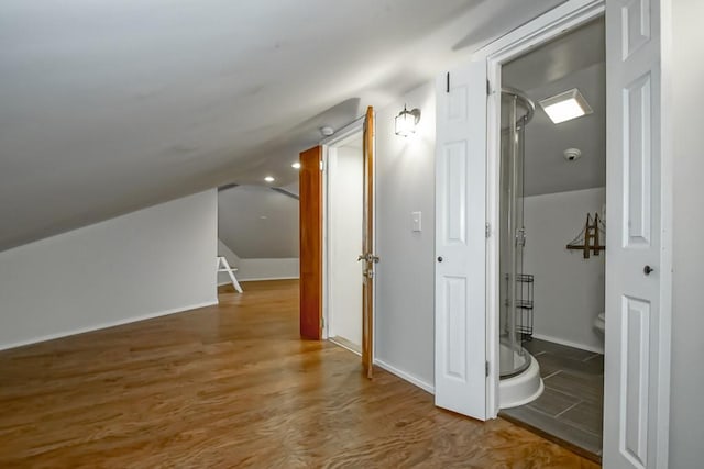 additional living space featuring wood-type flooring and vaulted ceiling