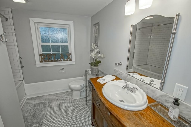 full bathroom featuring tiled shower / bath, tile patterned flooring, vanity, and toilet