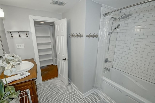 bathroom with tile patterned floors, shower / bath combo with shower curtain, and vanity