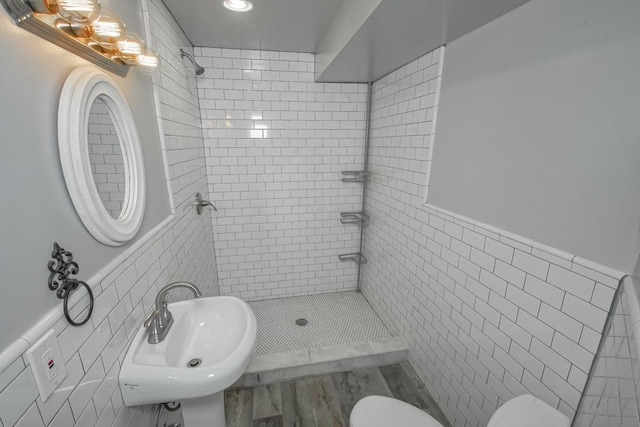 bathroom with sink, tile walls, and toilet