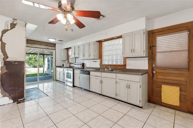 kitchen with white cabinets, ceiling fan, light tile patterned flooring, sink, and stainless steel appliances