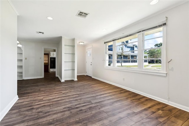 unfurnished living room featuring dark wood-type flooring and crown molding